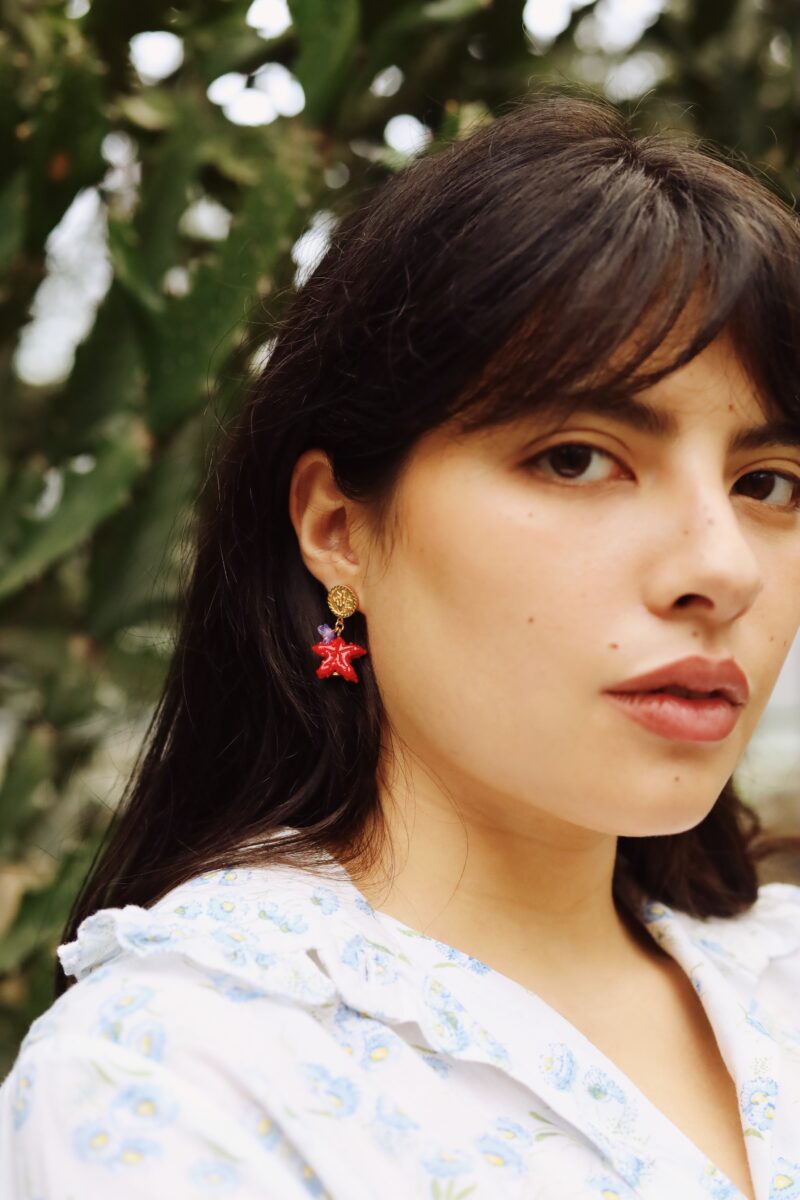 girl wearing earrings. Red star with lavender flower